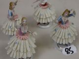 four porcelain figurines of a woman in a pink dress and a man in a blue shirt
