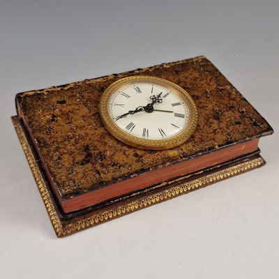 une horloge posée sur un livre, sur une table