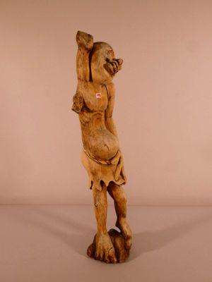 une statue en bois représentant un homme tenant une balle