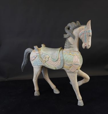 une petite statue représentant un cheval, posée sur une surface noire