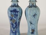 une paire de vases bleus et blancs posés sur une table blanche