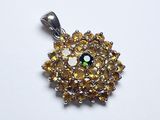 une image représentant un pendentif en forme de diamant jaune et blanc posé sur une surface blanche