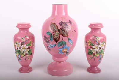 trois vases roses posés les uns à côté des autres sur une surface blanche