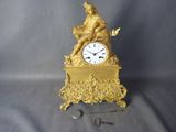 une horloge en or surmontée d'une statue
