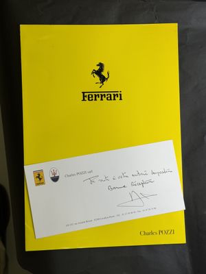 le logo Ferrari sur un dossier jaune auquel est attachée une note