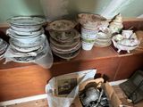 many plates and bowls on a shelf in a room