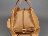 beige leather handbag on grey background with zippers and handles