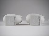 pair of white ceramic salt and pepper shakers on a white surface