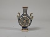 a blue and white vase sitting on a white surface