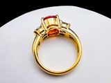 an image of a gold ring with a red stone in it