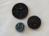 two black buttons with a star on them sitting on a white surface