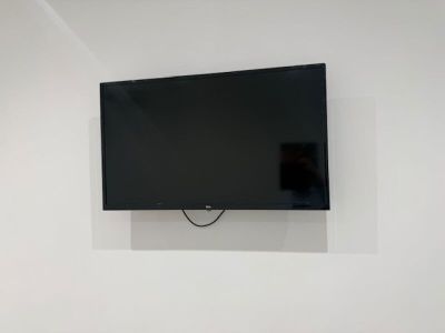 une télévision à écran plat fixée au mur au-dessus d'un lit