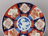 une image représentant une assiette décorative ornée d'un motif bleu et rouge