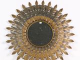 un motif « sunburst » doré et noir sur un mur blanc
