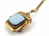 a close up of a necklace with a blue stone on it
