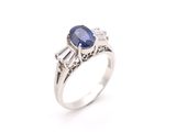 a close up of a ring with a sapphire and diamonds