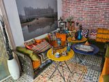 a living room with a couch, table, chairs, and a picture on the wall