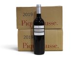 La bouteille de vin est posée à côté de deux cartons de vin.