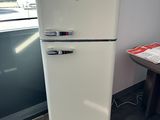 a white refrigerator sitting next to a window in a room