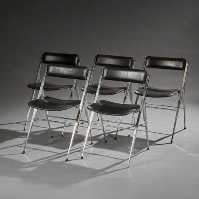 trois chaises pliantes en cuir noir posées sur un sol blanc