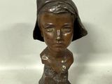 a statue of a woman with a hat on her head