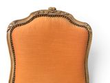 an old chair with a gold frame and orange upholstered upholstered seat