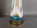 a white vase with blue and pink flowers on it