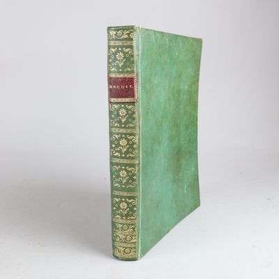 an old book sitting on top of a white table next to a white wall