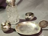 a silver plate and a silver salt shaker on a table