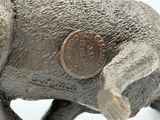 a small elephant statue with a penny on it ' s back