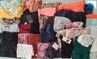 une grosse pile de vêtements posée sur une étagère