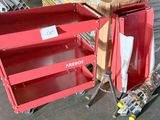 a red box with a sign on it sitting next to a pile of wood