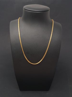 a gold chain necklace on a mannequin display