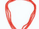 a coral beaded necklace with a gold clasp