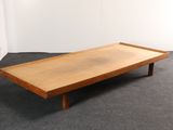 une photo d'une table basse en bois posée sur un sol recouvert de moquette