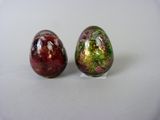 pair of red and green marble eggs sitting on a white surface