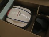 une souris blanche et bleue dans une boîte avec une souris noire