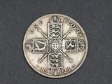 a close up of a silver coin with a cross on it