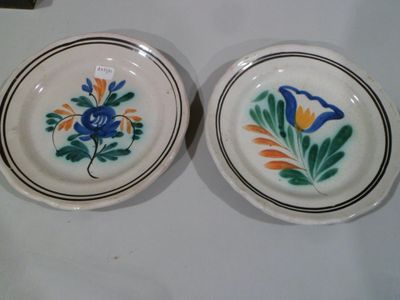 deux assiettes avec des fleurs et des feuilles peintes dessus, assises sur une table