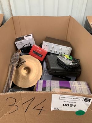 une boîte en carton remplie de matériel musical et un chapeau