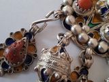 a close up of a necklace with many charms on it