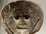 a wooden bowl with a face on it on a stand