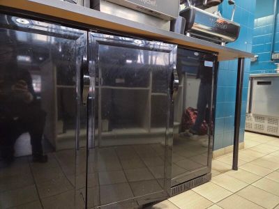 stainless steel double door freezer in commercial kitchen with tiled floor