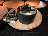 une table sur laquelle est posé un pot, posée elle-même sur une table en bois