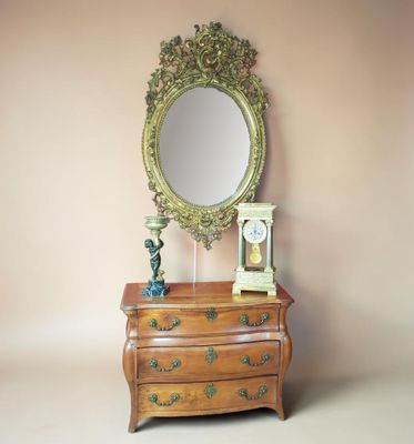 a dresser with a mirror and a clock on it