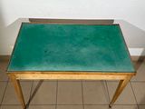 a small table with a green top on a tiled floor
