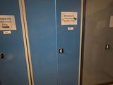 trois casiers bleus dans une pièce dont les portes sont munies d'étiquettes