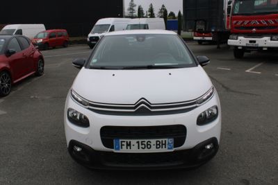 une Citroën blanche garée sur un parking à côté d'autres voitures