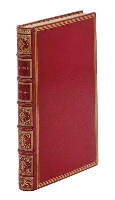 un vieux livre rouge aux bords dorés sur fond blanc