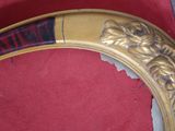 une photo d'un miroir au cadre doré posé sur un tapis rouge